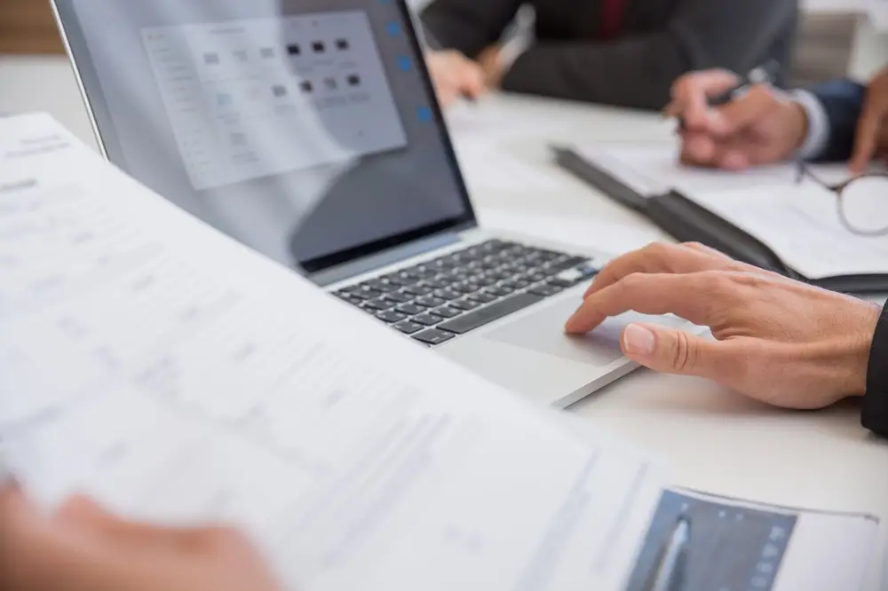 Profesionales revisando documentos de trabajo en una firma consultora