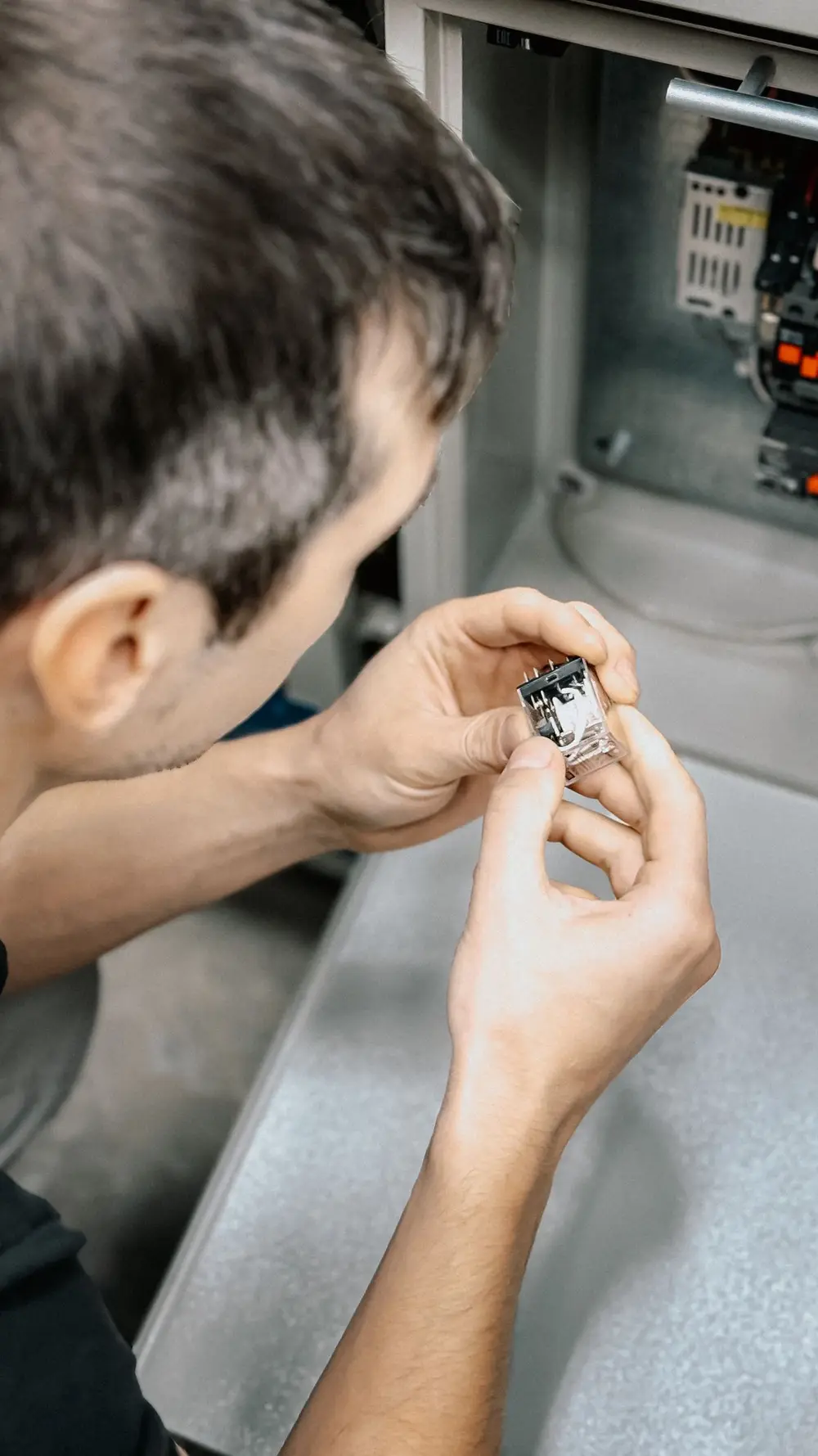 Técnico examinando un componente electrónico de mantenimiento industrial